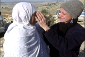 women from different sides of the Israel Palestine conflict embrace